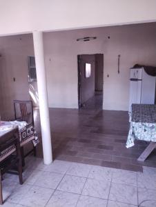 an empty room with two beds and a refrigerator at Casa Centro Parajuru in Parajuru