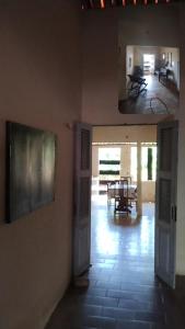 duas fotos de um corredor com um quarto com uma mesa em Casa Centro Parajuru em Parajuru
