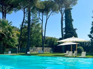 uma piscina com cadeiras e um guarda-sol em Borgo Studiati Relais em Pugnano