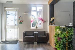 a waiting room with a leather chair in front of a door at Croft Court Hotel in London