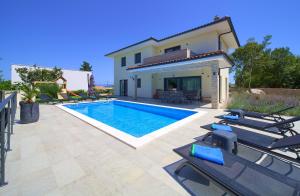 a villa with a swimming pool and a house at Villa Andante in Krk