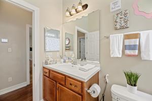 ein Bad mit einem Waschbecken und einem Spiegel in der Unterkunft Burnside Beauty 4BR Pingpong Patio in Tallahassee