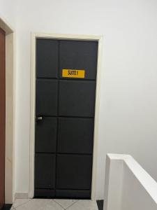 eine schwarze Tür mit einem Schild, das die Suite liest in der Unterkunft Suite 1, Casa Amarela, Segundo Andar in Nova Iguaçu