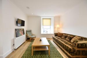 a living room with a couch and a table at Troon Portland Apt A in Troon