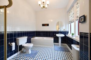 a bathroom with a toilet and a tub and a sink at Dunvegan Apartment Troon in Troon