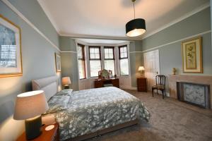 a bedroom with a bed and a fireplace at Dunvegan Apartment Troon in Troon