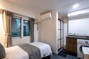 K Stay 3rd Myeongdong City في سول: غرفة نوم بسرير ومغسلة ونافذة