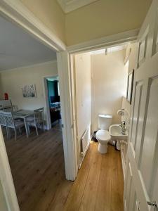 a bathroom with a toilet and a dining room at Comfortable 3 Bed Perfect For Contractors in Lincolnshire