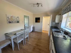 a kitchen and dining room with a table and a counter at Comfortable 3 Bed Perfect For Contractors in Lincolnshire
