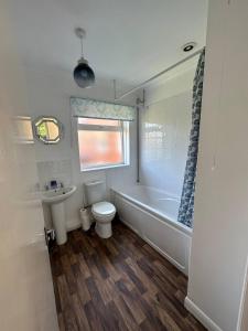 a bathroom with a tub and a toilet and a sink at Comfortable 3 Bed Perfect For Contractors in Lincolnshire