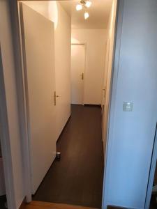 - un couloir dans un appartement doté de murs blancs et de parquet dans l'établissement Sublime appartement climatisé proche Orly pour 8 personnes, à Vigneux-sur-Seine