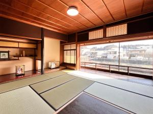 a room with a large window and yoga mats at Hostel Miyagawa by Murasaki Ryokan in Takayama