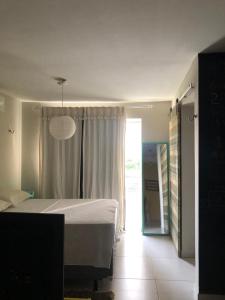 een slaapkamer met een bed en een groot raam bij Hotel Oiticica in Fortaleza