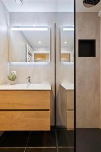 een badkamer met een wastafel en een spiegel bij Beachday II met garagebox in Nieuwpoort