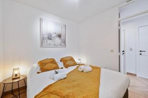 a white bedroom with a large bed with pillows at Beachday II met garagebox in Nieuwpoort