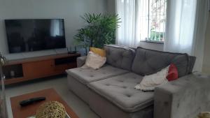 ein Wohnzimmer mit Sofa und Fernseher in der Unterkunft Casa Aconchegante in Saquarema