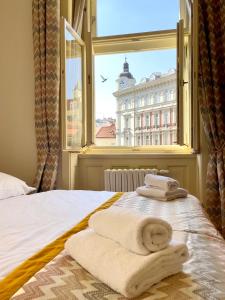 a bed with towels on it with a window at Havelska Old Town Residence in Prague