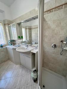 bagno con lavandino e doccia di La Casa di Ele, parcheggio privato gratuito a La Spezia