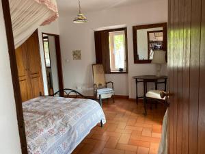 una camera con letto, tavolo e specchio di Corgos, Flores a Monchique