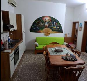 cocina con mesa y sofá verde en Il giardino di Ercole, en San Pietro Vernotico