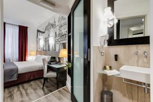 ローマにあるResidenza A -Via Veneto Fashion Rooms -self check-inのベッド、デスク、シンクが備わるホテルルームです。