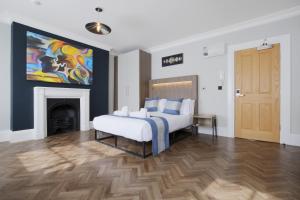 a bedroom with a bed with a fireplace and a painting at Imperial York Street Apartments in London