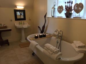 a bathroom with a bath tub and a sink at Fauhope Country House in Melrose