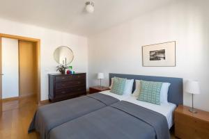um quarto com uma cama grande e um espelho em Ola Lisbon - Penha de Franca em Lisboa