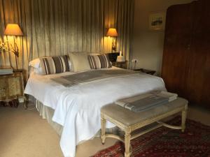 a bedroom with a large white bed and a table at Fauhope Country House in Melrose