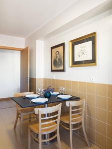 uma sala de jantar com uma mesa preta e cadeiras em Ola Lisbon - Penha de Franca em Lisboa