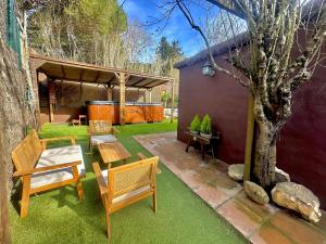 een patio met een tafel en stoelen en een boom bij La Villa Verde in Tarifa