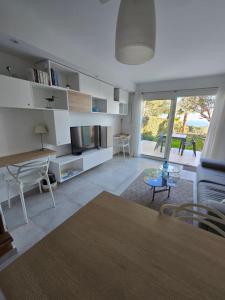 sala de estar con TV, sofá y mesa en Villa Perle d'or vue mer en Saint-Raphaël