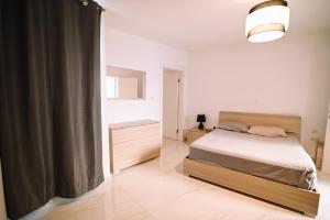 Un dormitorio con una cama y una ventana grande. en Spacious 3 bedroom in Sliema!, en Sliema
