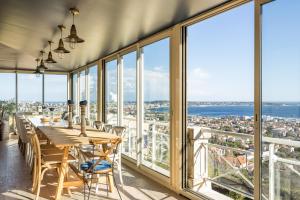 ein Esszimmer mit einem Tisch und Stadtblick in der Unterkunft Villa Bastide : Sea view / Hot Tub / Sauna in Vallauris