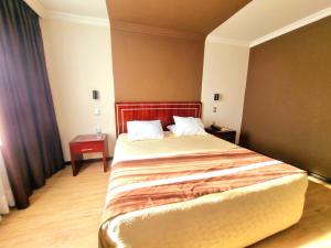 a bedroom with a large bed with a red headboard at Hotel El Araucano in Concepción