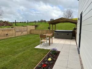 a backyard with a table and a hot tub at Springwell Lodge in Exeter