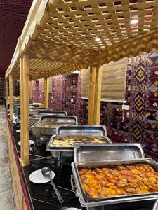 a buffet line with many trays of food at Shaheen Camp Wadi rum in Wadi Rum