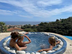 drie kinderen zitten in een hot tub bij Villa Bastide : Sea view / Hot Tub / Sauna in Vallauris