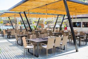 a restaurant with tables and chairs and a roof at Hotel Pescarus Port Bicaz in Bicaz