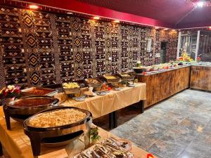 a restaurant with several tables of food and a wall of wine bottles at Shaheen Camp Wadi rum in Wadi Rum