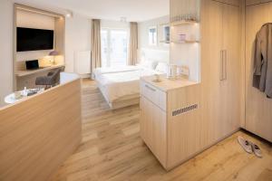 ein Hotelzimmer mit einem Schlafzimmer und einem Bett in der Unterkunft Hotel Stranddistel in Norderney