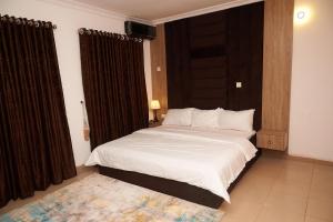 a bedroom with a large bed with white sheets at 1118 Serenity Residence in Abuja