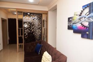 a living room with a couch and a painting on the wall at 1118 Serenity Residence in Abuja