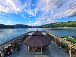 a pier on a lake with people walking on it at Hotel Pescarus Port Bicaz in Bicaz
