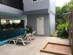 a patio with chairs and a swimming pool at Condo Centerviews Bangsaray Beach in Bang Sare