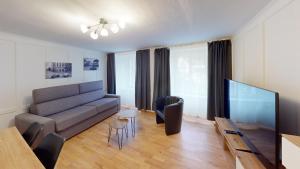 ein Wohnzimmer mit einem Sofa und einem Flachbild-TV in der Unterkunft Zentrale 2,5 Altstadtwohnung - Boxspringbett - Smart TV in Chur