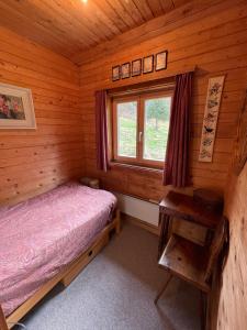 um quarto com uma cama e uma janela num chalé de madeira em Zauberberg in voller Pracht em Sertig Döfli