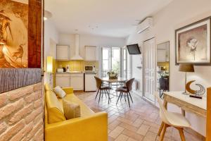 サルラ・ラ・カネダにあるLa Villa des Consuls - Gîte de tourisme de charmeの黄色いソファとテーブルのあるリビングルーム