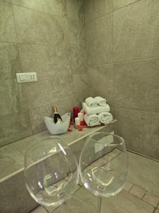 een badkamer met 2 wijnglazen en handdoeken bij LUXUITE SPA con PISCINA e JACUZZI in Alberobello