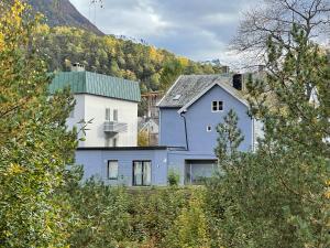 uma casa azul e branca com uma montanha ao fundo em Bakkebo Trollstigen em Åndalsnes